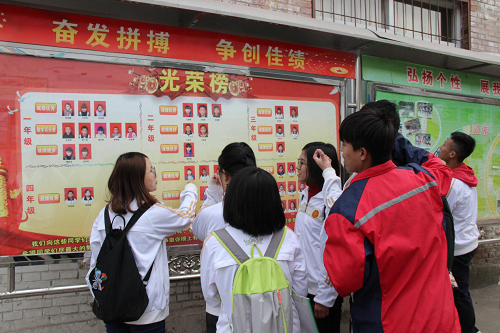 同学们观看学校光荣栏